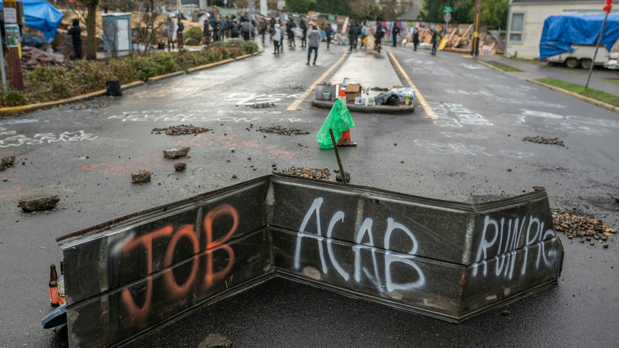 PORTLAND, OR - DECEMBER 09: Protesters walk past part of a barricade near the Red House on Mississippi on December 9, 2020 in Portland, Oregon. Police and protesters clashed during an attempted eviction Tuesday, leading protesters to establish a barricade around the Red House.