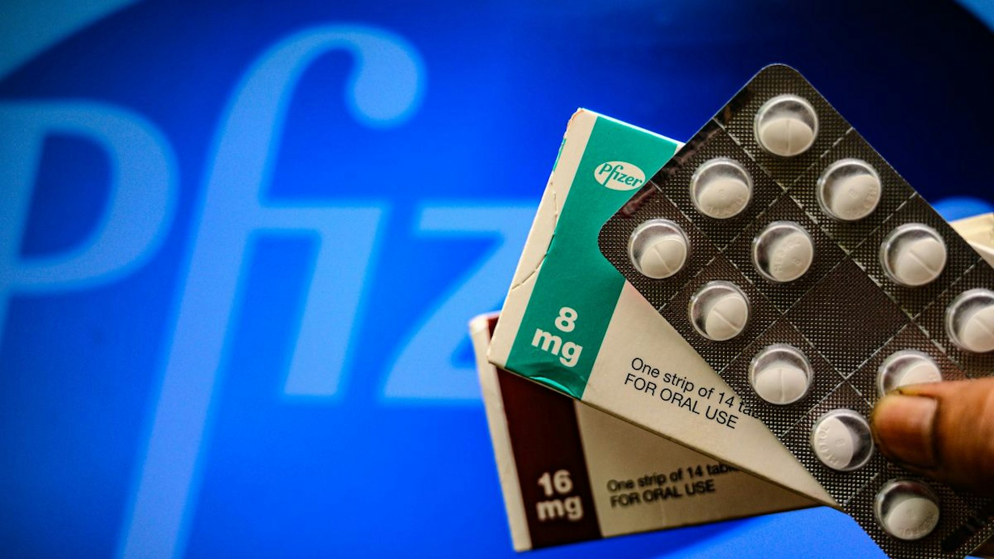 Medicine pills are seen with Pfizer logo in this illustration photo taken in Tehatta, West Bengal, India on 29 April 2021.