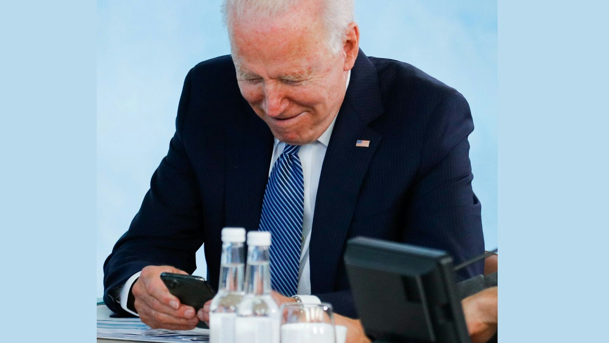 CARBIS BAY, CORNWALL - JUNE 13: U.S. President Joe Biden reads his phone as he attends a plenary session during G7 summit in Carbis Bay on June 13, 2021 in Cornwall, United Kingdom. UK Prime Minister, Boris Johnson, hosts leaders from the USA, Japan, Germany, France, Italy and Canada at the G7 Summit.