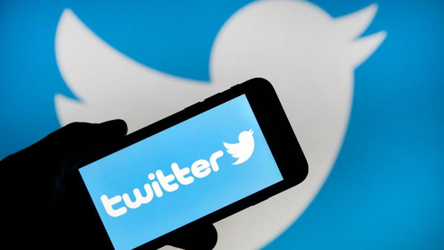 In this photo illustration the Twitter logo is displayed on the screen of an iPhone in front of a computer screen displaying a Twitter logo on February 07, 2019 in Paris, France.