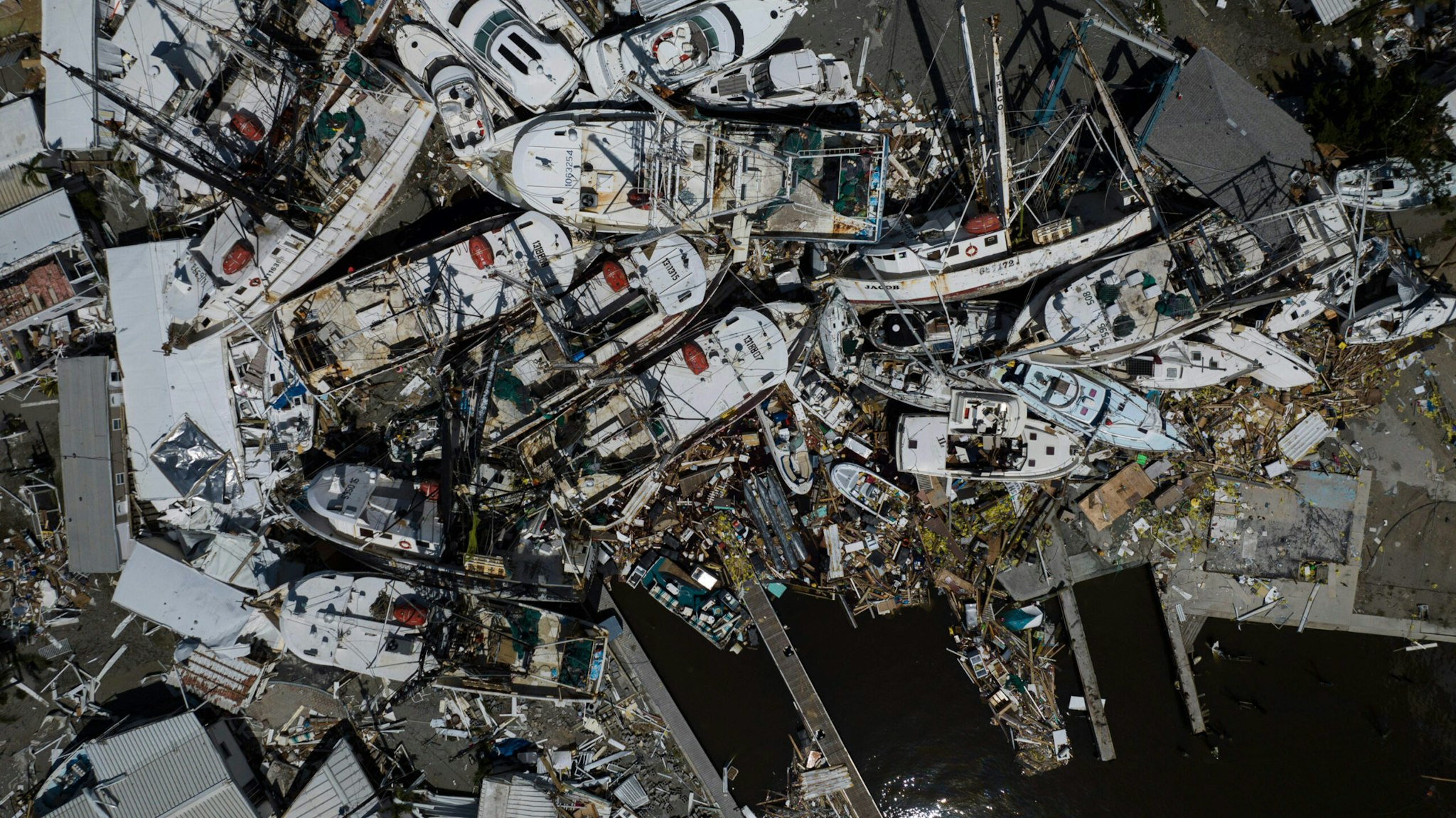 An aerial picture taken on September 29, 2022 shows piled up boats in the aftermath of Hurricane Ian in Fort Myers, Florida.