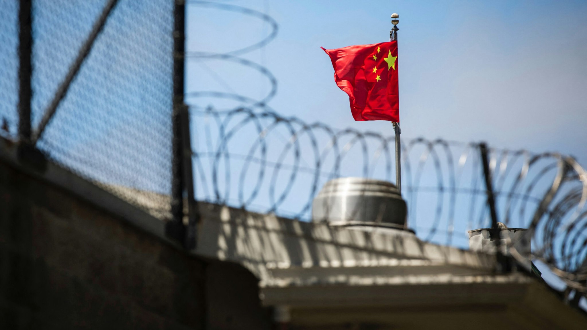 The flag of the People's Republic of China flies behind barbed wire at the Consulate General of the People's Republic of China in San Francisco, California on July 23, 2020.