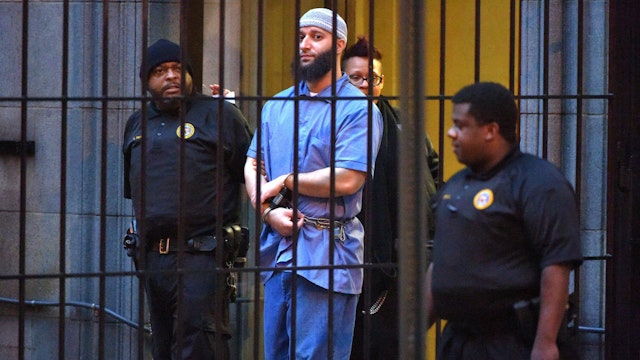 Officials escort "Serial" podcast subject Adnan Syed from the courthouse on Feb. 3, 2016, following the completion of the first day of hearings for a retrial in Baltimore, Md.
