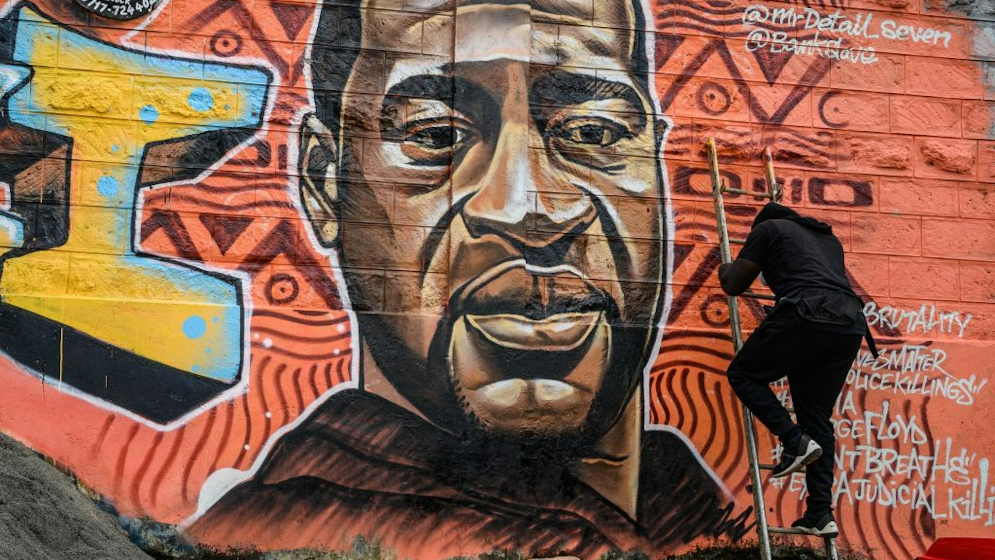 Kenyan mural artist Allan Mwangi, also known as Mr.detail.seven, paints a graffiti mural in the Kibera slum in Nairobi on June 3, 2020, depicting the American, George Floyd, who was killed by a police officer in Minneapolis, in the United States. (Photo by Gordwin ODHIAMBO / AFP) / RESTRICTED TO EDITORIAL USE - MANDATORY MENTION OF THE ARTIST UPON PUBLICATION - TO ILLUSTRATE THE EVENT AS SPECIFIED IN THE CAPTION (Photo by GORDWIN ODHIAMBO/AFP via Getty Images)