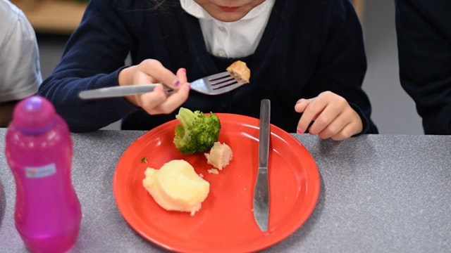 A pupil eats her cooked hot dinner during her lunch break in the canteen at St Luke's Church of England Primary School in East London on September 3, 2020. - Pupils in Britain have on Thursday begun to return to schools for the first time since they were all closed in March, due to the COVID-19 pandemic. (Photo by Daniel LEAL / AFP) (Photo by DANIEL LEAL/AFP via Getty Images)