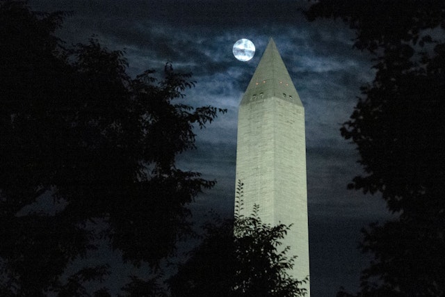 WASHINGTON, DC - AUGUST 11: The moon is obscured by clouds as it passes behind the Washington Monument on August 11, 2022 in Washington, DC. The so-called Sturgeon Moon is the fourth and final super moon of 2022. (Photo by Chip Somodevilla/Getty Images)
