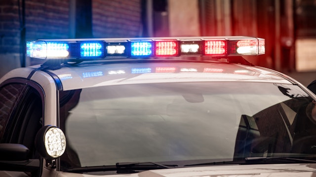 Modern LED light bar on police cruiser flashing red and blue emergency lights.