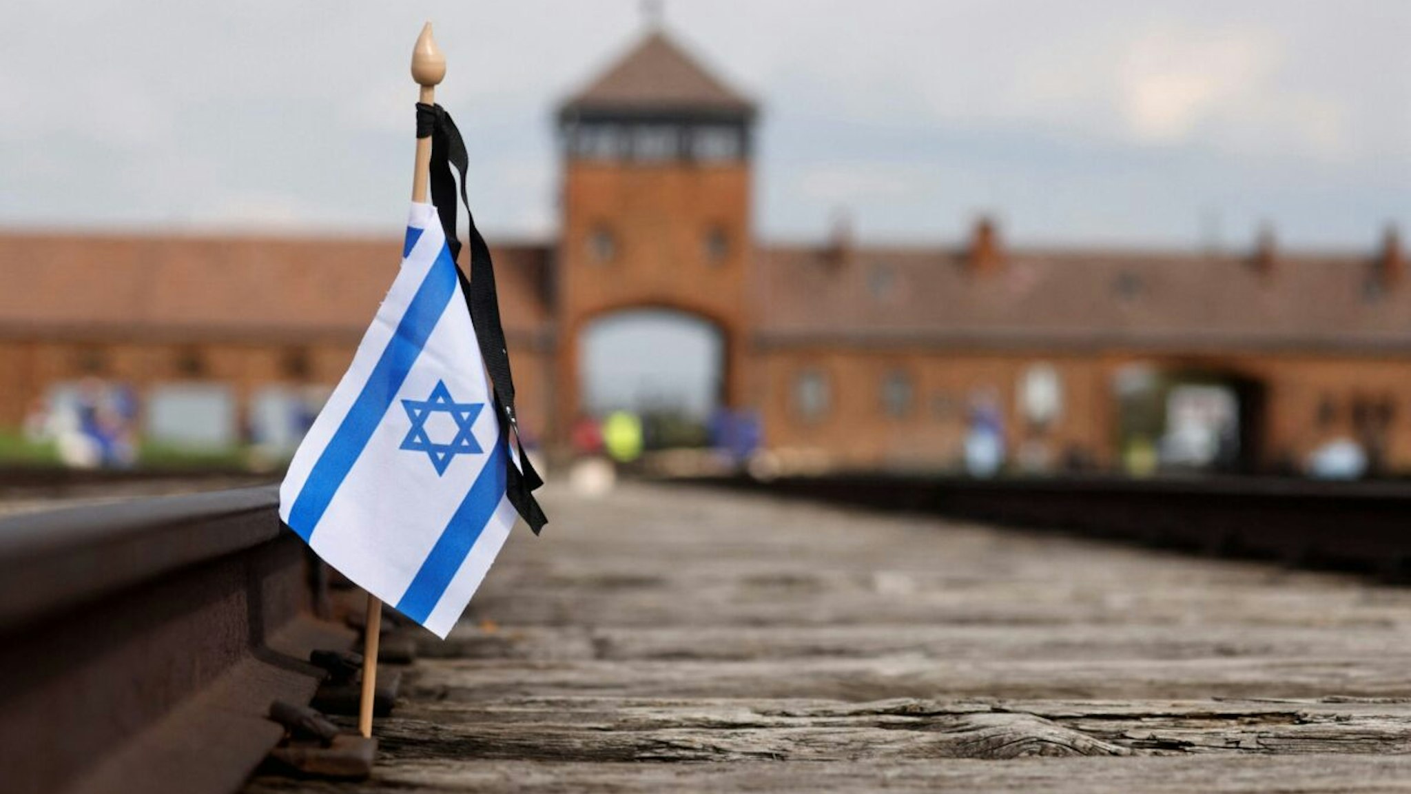 A small national flag of Israel has been placed on the rail tracks at the site of the former Auschwitz-Birkenau camp during commemorations to honour the victims of the Holocaust, near the historical gate of Birkenau (Auschwitz II) near the village of Brzezinka near Oswiecim, Poland on April 28, 2022