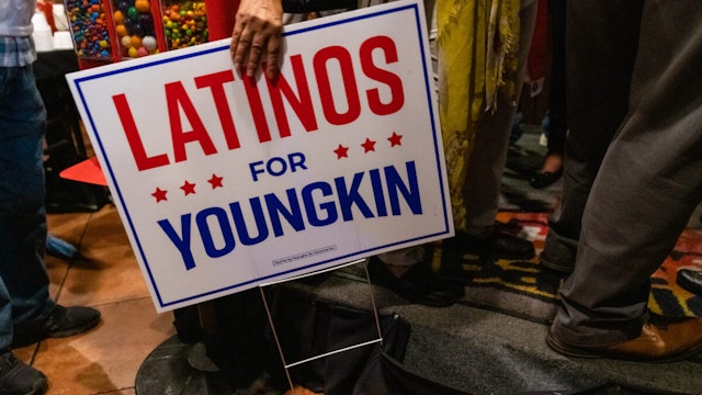 A person holds a Latinos for Youngkin sign after an event for Republican gubernatorial candidate Glenn Youngkin at Sabor A Barrio Restaurant in Manassas, Va. on October 16, 2021