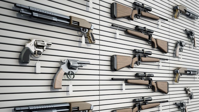 Fictitious firearms hanging on the wall of a gun store. 3D rendering.