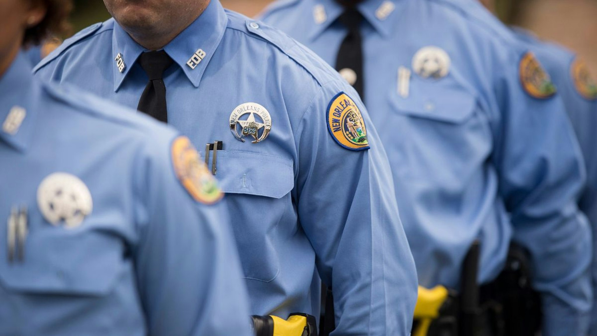 Twenty nine new New Orleans police officers stand during a pinning ceremony at the University of New Orleans as they graduate from the New Orleans Police Department's training academy in New Orleans, LA on Wednesday, September 02, 2015.