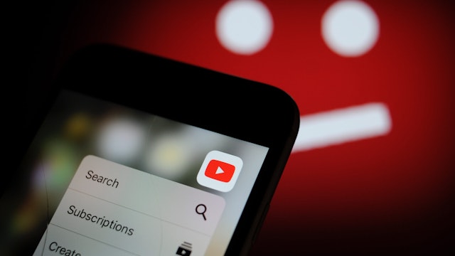 The YouTube video sharing application is seen on an iPhone with the symbol for unavailable content in the background in this photo illustration on December 1, 2017.