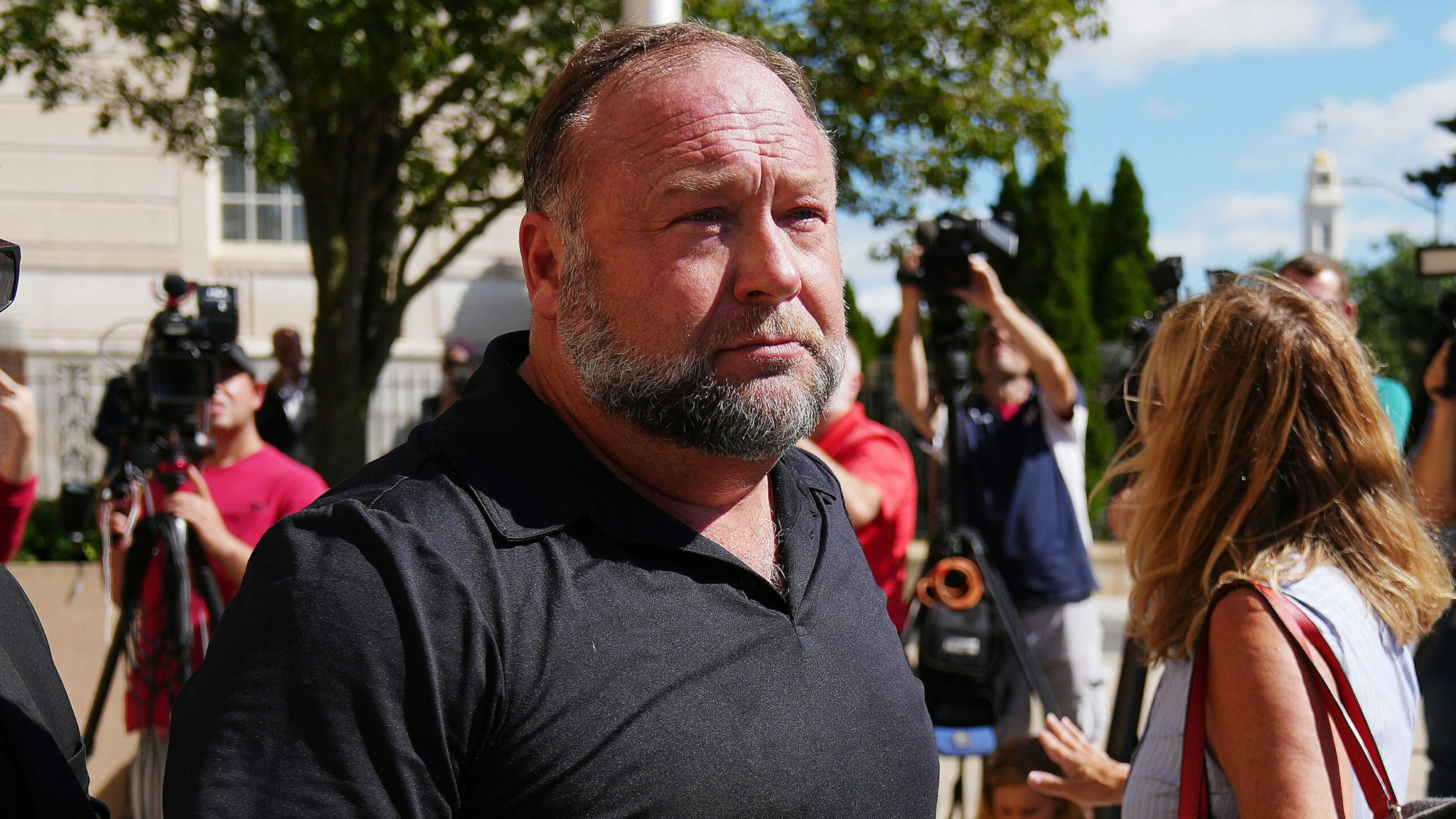 WATERBURY, CONNECTICUT - SEPTEMBER 21: InfoWars founder Alex Jones walks outside Waterbury Superior Court during his trial on September 21, 2022 in Waterbury, Connecticut. Jones is being sued by several victims' families for causing emotional and psychological harm after they lost their children in the Sandy Hook massacre. A Texas jury last month ordered Jones to pay $49.3 million to the parents of 6-year-old Jesse Lewis, one of 26 students and teachers killed in the shooting in Newtown, Connecticut.