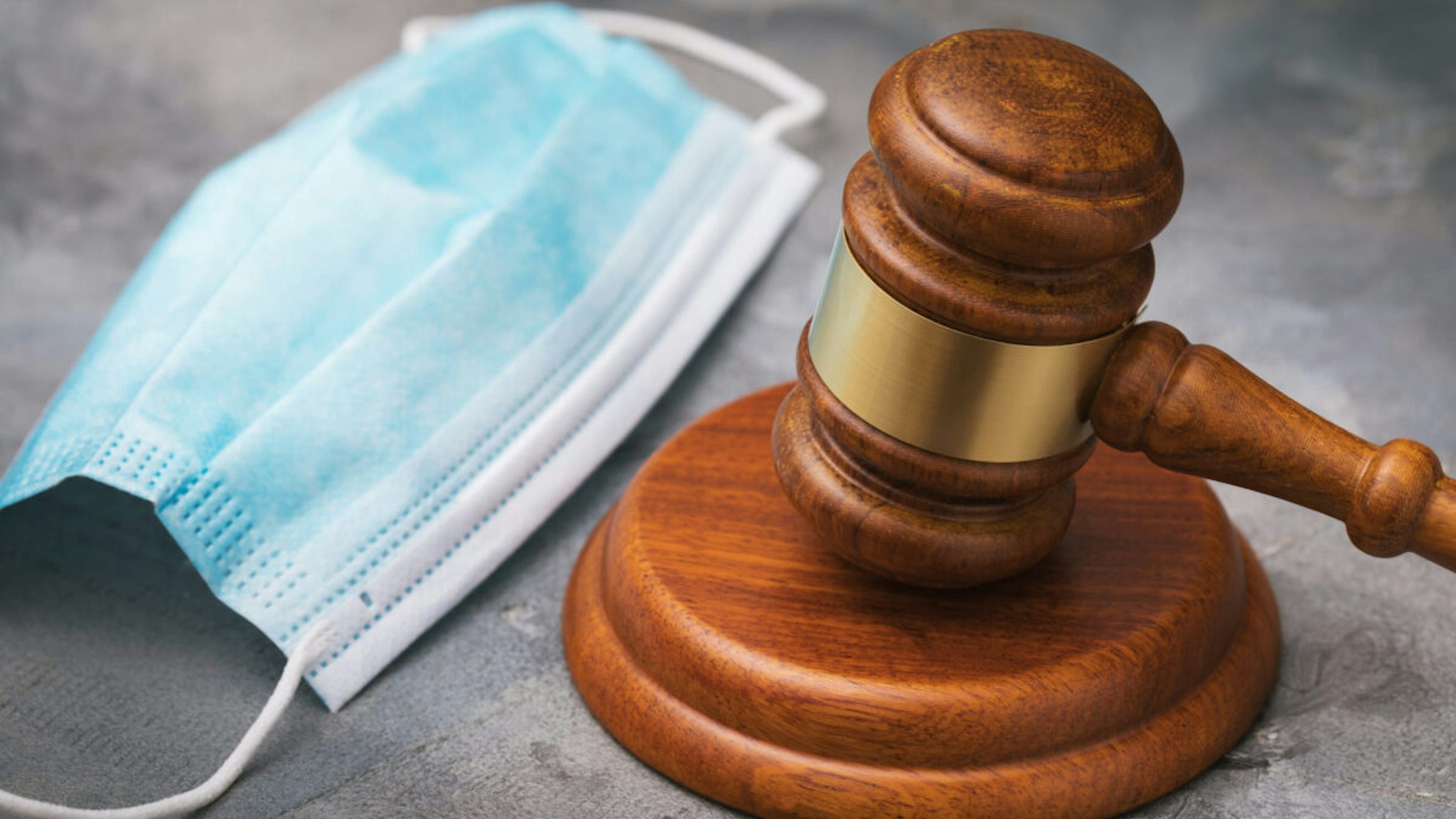 Judges gavel and medical mask on the table close-up, the concept of punishment for violating the quarantine regime