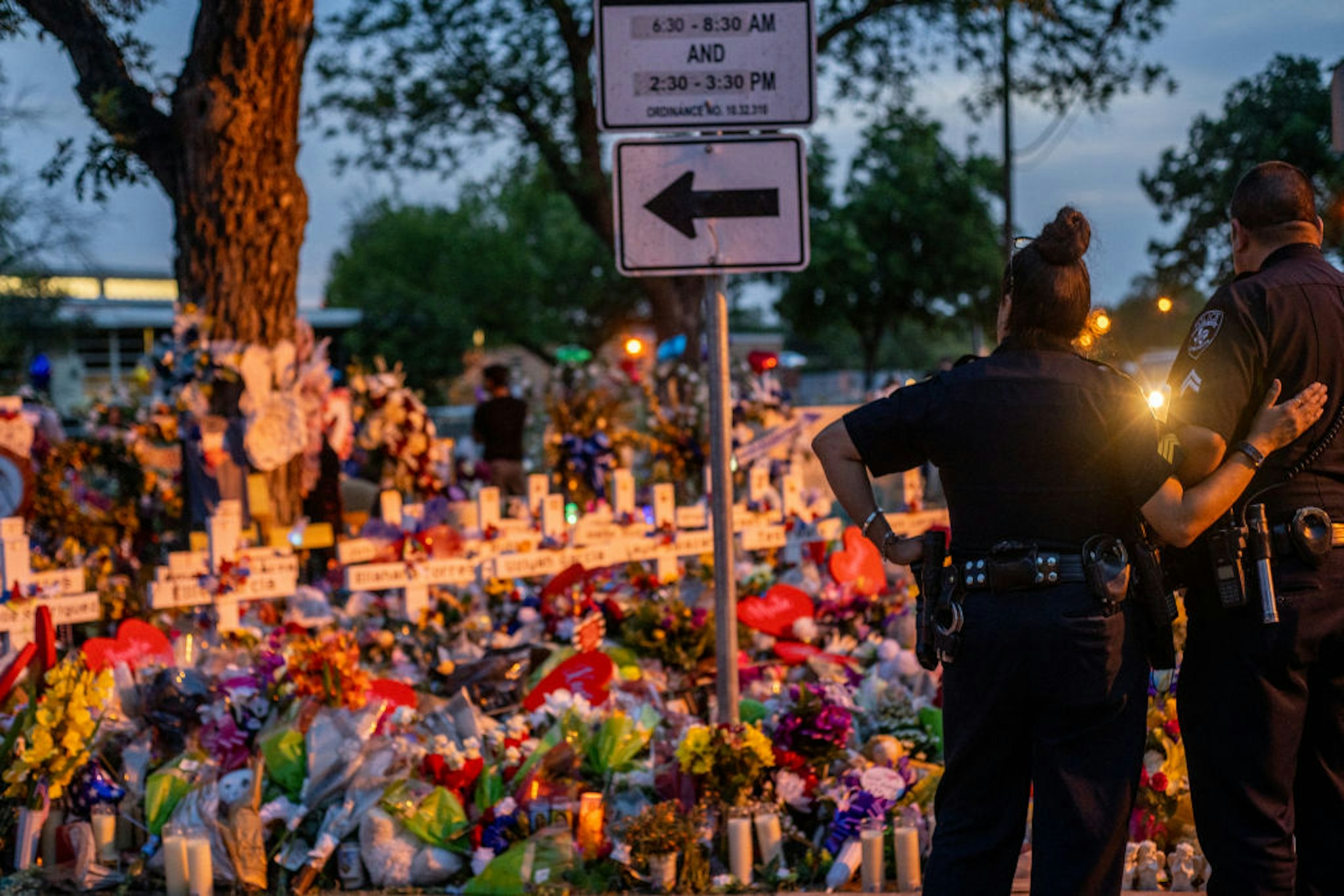 UVALDE, TEXAS - MAY 31: Police officers stand together at a memorial dedicated to the 19 children and two adults killed on May 24th during the mass shooting at Robb Elementary School on May 31, 2022 in Uvalde, Texas. Opening wakes and funerals for the 21 victims will be scheduled throughout the week.
