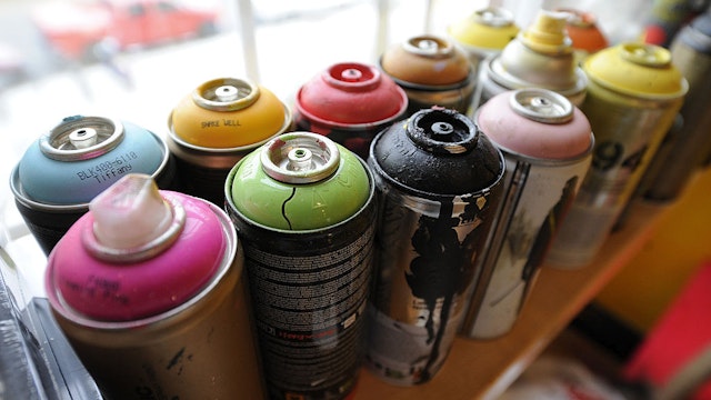 WASHINGTON, DC - JULY 08: Cans of spray paint sit lined up as artist, Brandon Hill works on artwork at VeraCruz Gallery on Sunday July 08, 2012 in Washington, DC in preparation for a show at the gallery. Hill along with Peter Chang make up, No Kings Collective. (Photo by Matt McClain for The Washington Post via Getty Images)