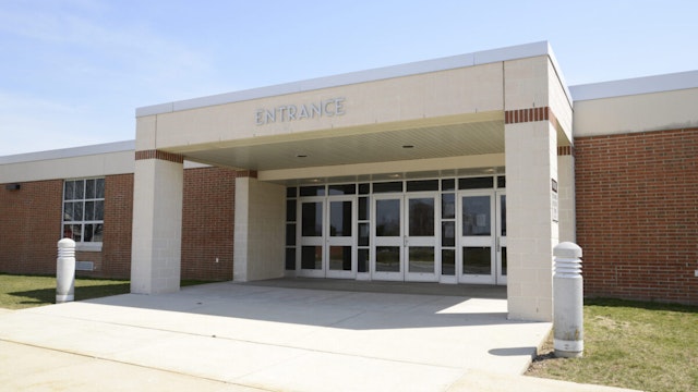 entrance for a modern school, with a covered entryway and sidewalk