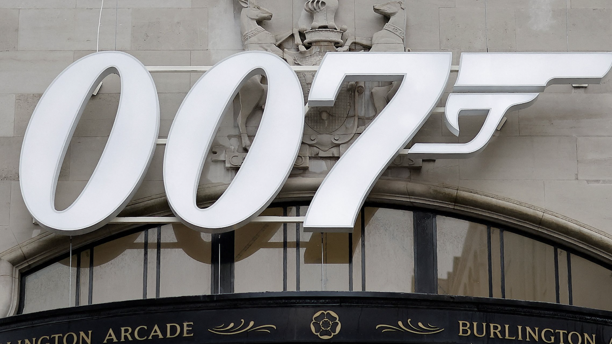 A pedestrian walks past a James Bond 007 logo above the entrance to Burlington Arcade in London on October 4, 2021, following the release of the latest James Bond film "No Time To Die" .