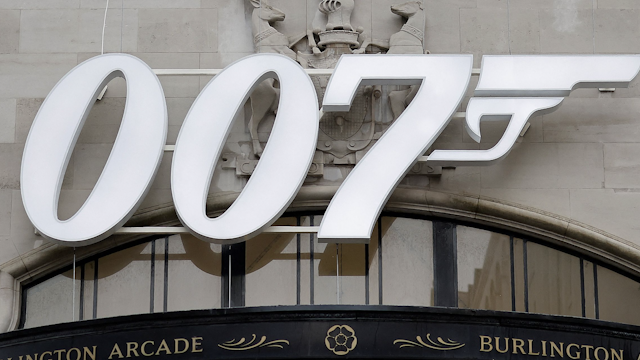 A pedestrian walks past a James Bond 007 logo above the entrance to Burlington Arcade in London on October 4, 2021, following the release of the latest James Bond film "No Time To Die" .