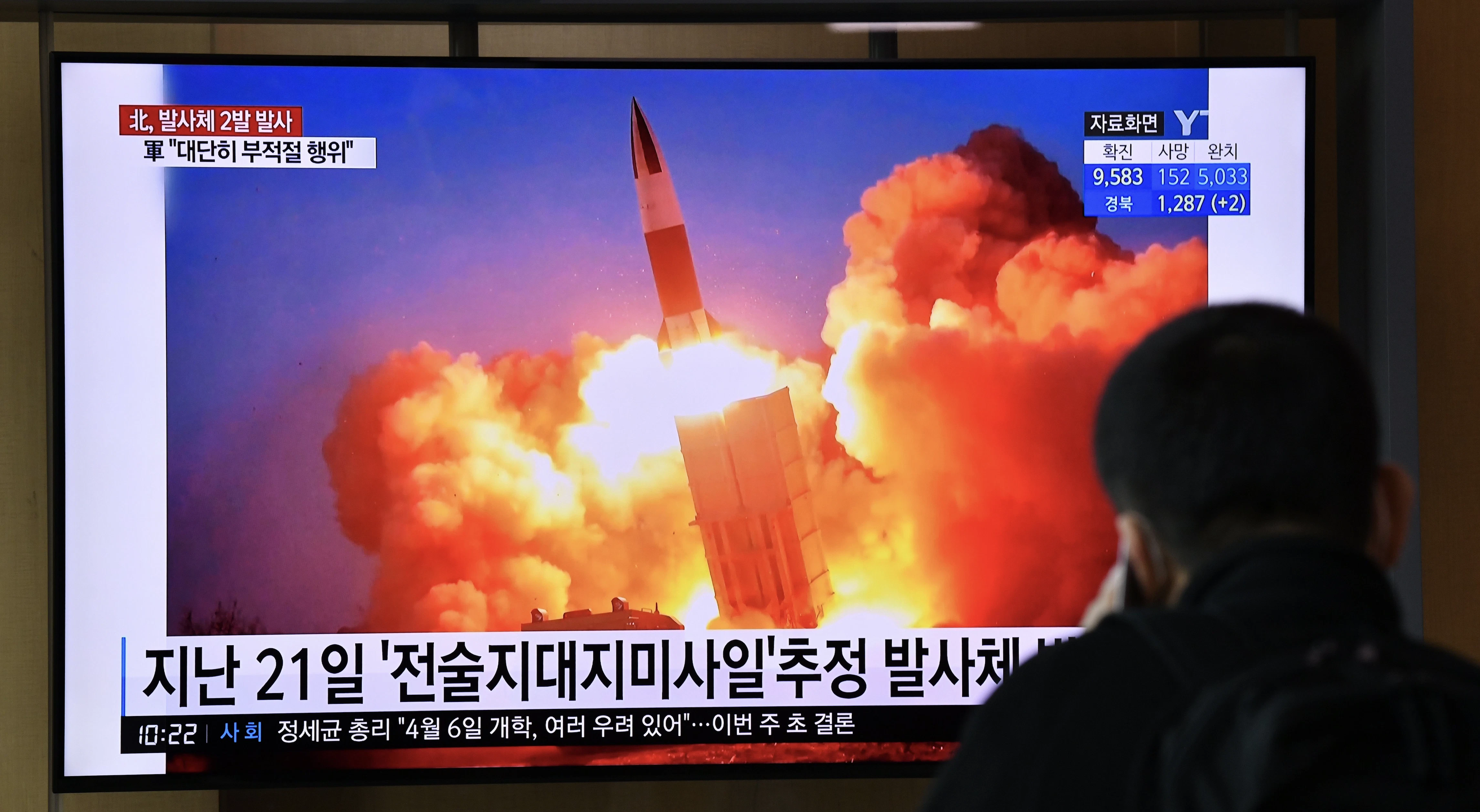 A man watches a news broadcast showing file footage of a North Korean missile test, at a railway station in Seoul on March 29, 2020. - North Korea fired what appeared to be two short-range ballistic missiles off its east coast on March 29, the fourth such launch this month as the world battles the coronavirus pandemic.