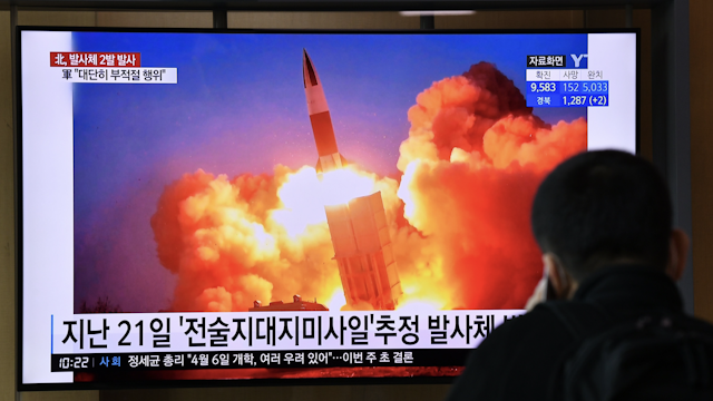 A man watches a news broadcast showing file footage of a North Korean missile test, at a railway station in Seoul on March 29, 2020. - North Korea fired what appeared to be two short-range ballistic missiles off its east coast on March 29, the fourth such launch this month as the world battles the coronavirus pandemic.