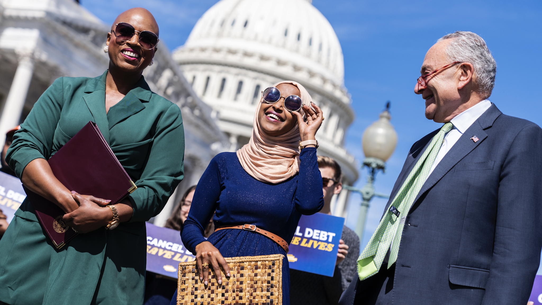 UNITED STATES - SEPTEMBER 29: From left, Reps. Ayanna Pressley, D-Mass., Ilhan Omar, D-Minn., and Senate Majority Leader Charles Schumer, D-N.Y., attend a news conference outside of the U.S. Capitol on the benefits of President Bidens student debt relief plan on Thursday, September 29, 2022.