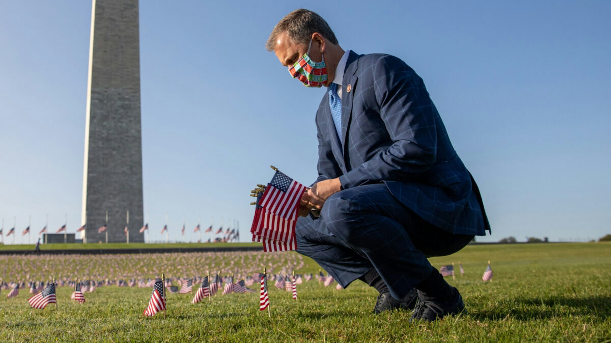 Representative Sean Casten, a Democrat from Illinois, places American flags at the Covid Memorial Project on the National Mall in Washington, D.C., U.S., on Tuesday, Sept. 22, 2020