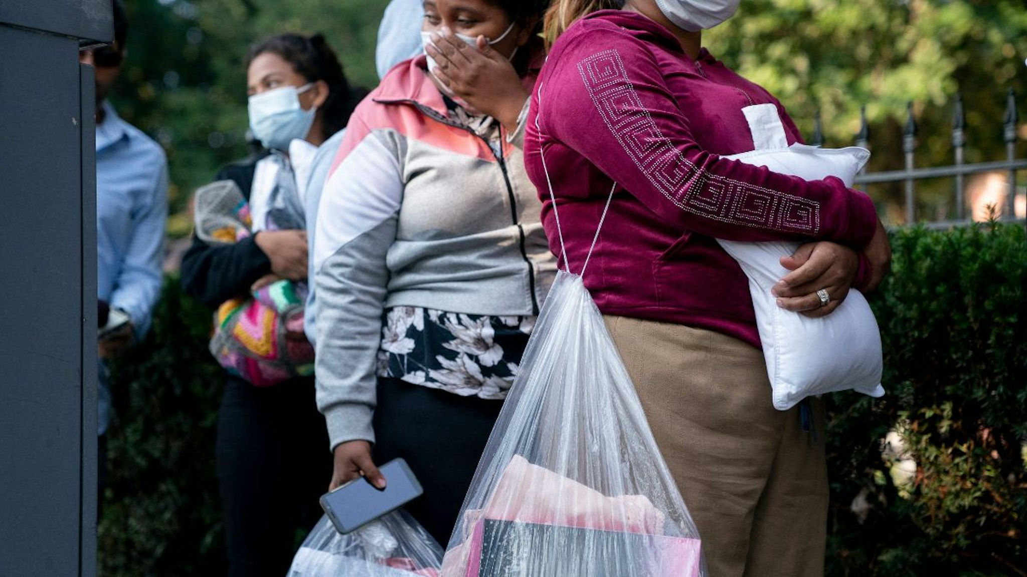 Migrants from Venezuela, who boarded a bus in Texas, wait to be transported to a local church by volunteers after being dropped off outside the residence of US Vice President Kamala Harris, at the Naval Observatory in Washington, DC, on September 15, 2022.