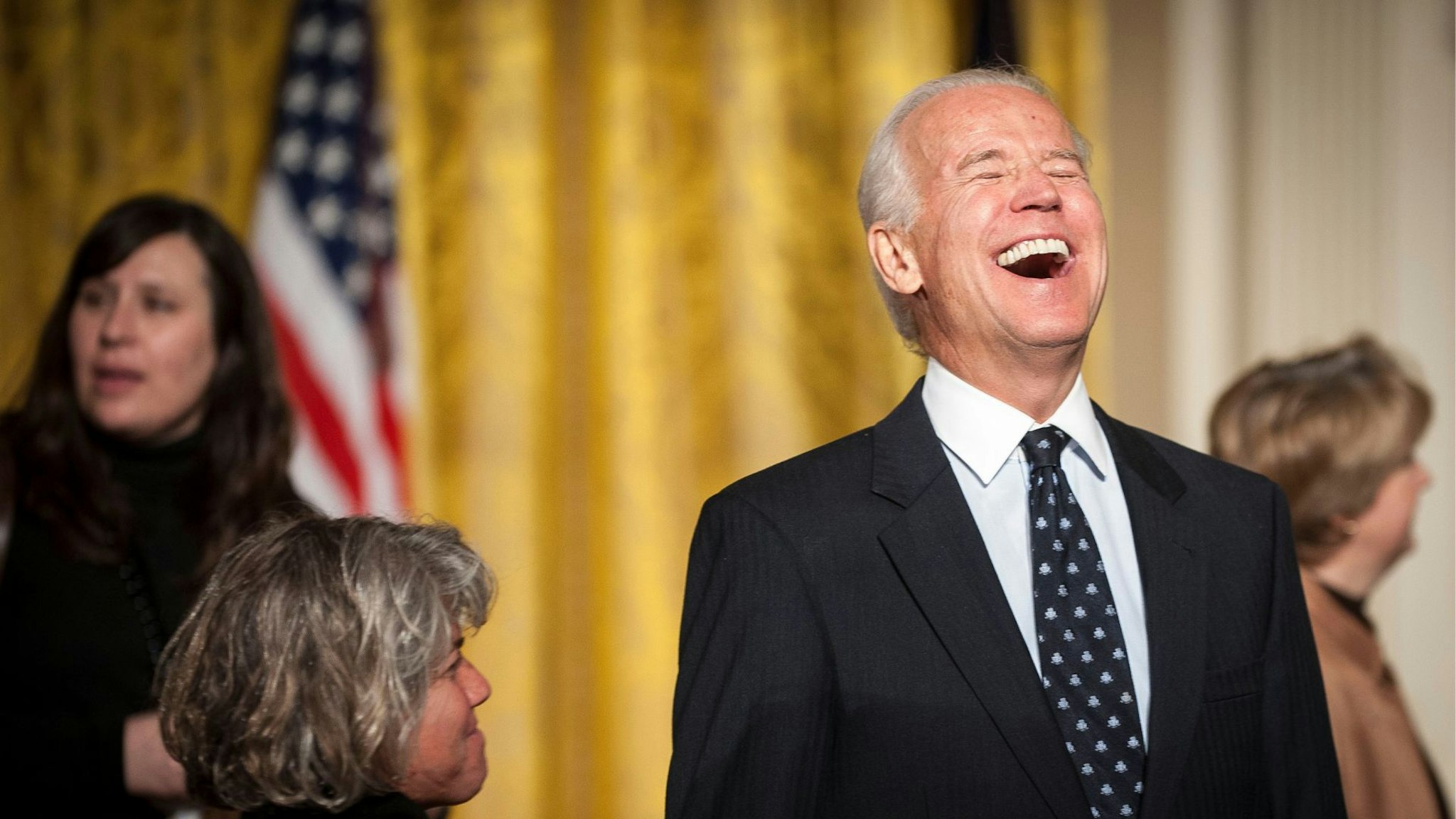 Bloomberg's Best Photos 2014: U.S. Vice President Joe Biden, right, laughs during an event for the Council on Women and Girls in the East Room of the White House in Washington, D.C., U.S., on Wednesday, Jan 22, 2014. U.S. President Barack Obama signed a presidential memorandum establishing a White House task force to protect students from sexual assault.