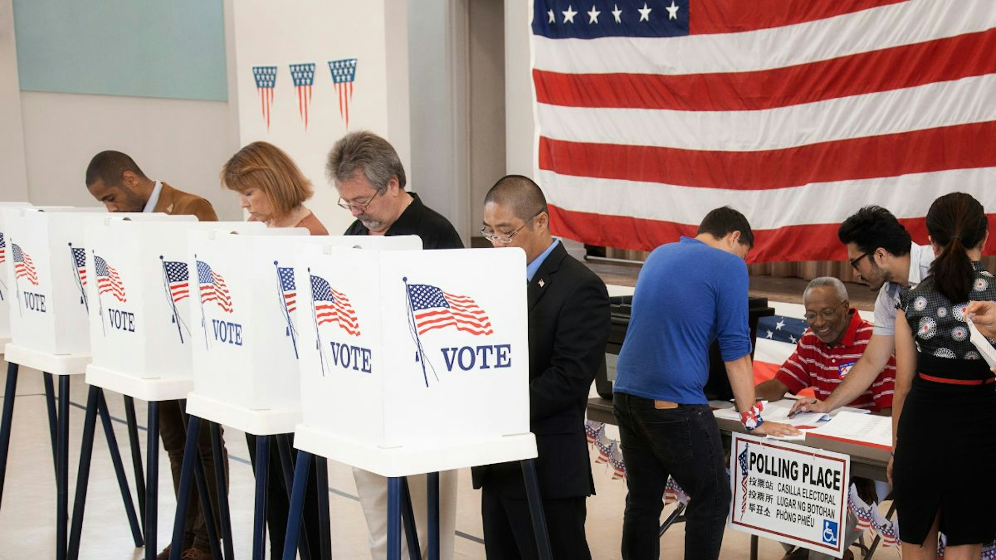 People voting in polling place - stock photo.