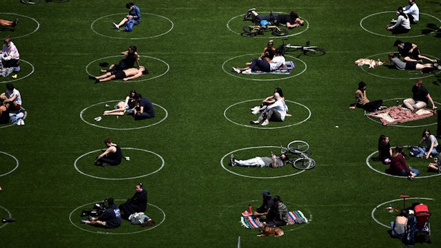 TOPSHOT - People are seen practising social distancing in white circles in Domino Park, during the Covid-19 pandemic on May 17, 2020 the in Brooklyn borough of New York City.