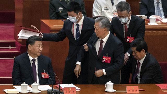 BEIJING, CHINA - OCTOBER 22: Chinese President Xi Jinping (L) looks on as former President Hu Jintao is helped to leave early from the closing session of the 20th National Congress of the Communist Party of China, at The Great Hall of People on October 22, 2022 in Beijing, China's Communist Party Congress is concluding today with incumbent President Xi Jinping expected to seal a third term in power.