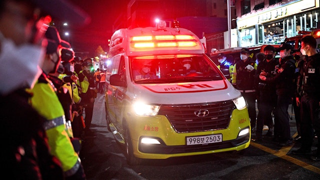 An ambulance drives past the area of a Halloween crush, which left at least 120 people dead, in the district of Itaewon in Seoul on October 30, 2022. - At least 120 people were killed on October 29 and some 100 were injured in a stampede in central Seoul when thousands crowded into narrow streets to celebrate Halloween, officials said.