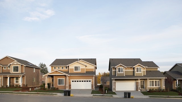 Row of houses with garbage and recycling bins on roadside - stock photo Washington, USA Thomas Northcut via Getty Images