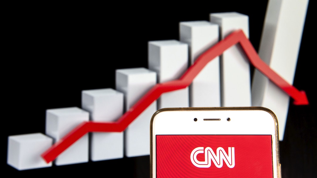 HONG KONG - 2018/12/14: In this photo illustration, the CNN logo is seen displayed on an Android mobile device with a decline loses graph in the background.