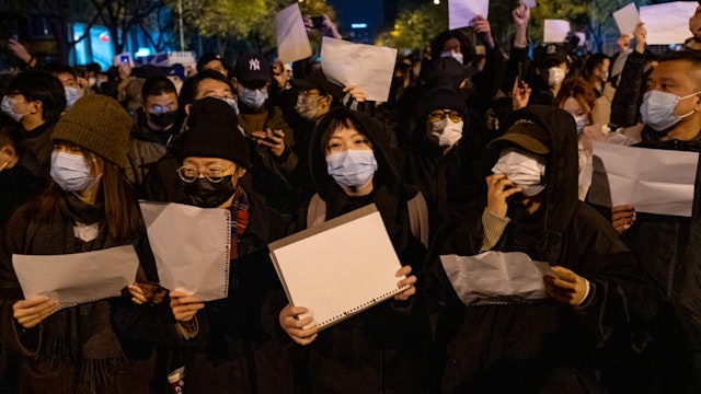 Demonstrators hold white signs as a form of protest during a protest against Zero Covid and epidemic prevention restrictions in Beijing, China, on Sunday, November 27, 2022