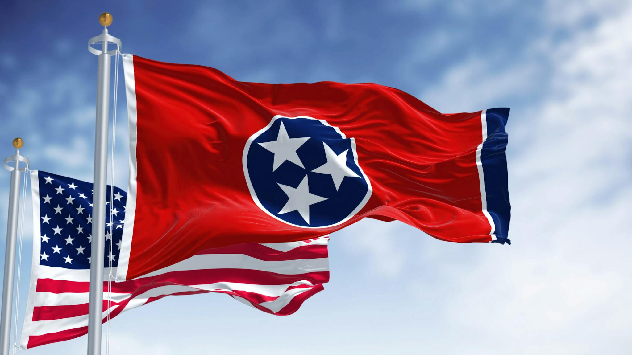 The Tennessee state flag waving along with the national flag of the United States of America