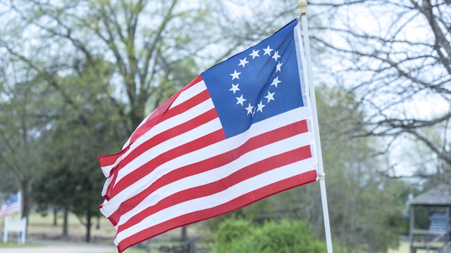 The Betsy Ross flag is an early design of the flag of the United States, popularly, but very likely incorrectly, attributed to Betsy Ross, using the common motifs of alternating red-and-white striped field with five-pointed stars in a blue canton. The first documented usage of this flag was in 1792. The flag features 13 stars to represent the original 13 colonies with the stars arranged in a circle.