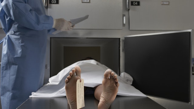 "Cadaver on autopsy table, label tied to toe, close-up" - stock photo