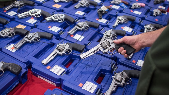 CHANTILLY, VA - OCTOBER 3: People look at handguns as thousands of customers and hundreds of dealers sell, show, and buy guns and other items during The Nation's Gun Show at the Dulles Expo Center which is the first major gun show in the area since the Oregon shooting in Chantilly, VA on Saturday, October 03, 2015. (Photo by Jabin Botsford/The Washington Post via Getty Images)