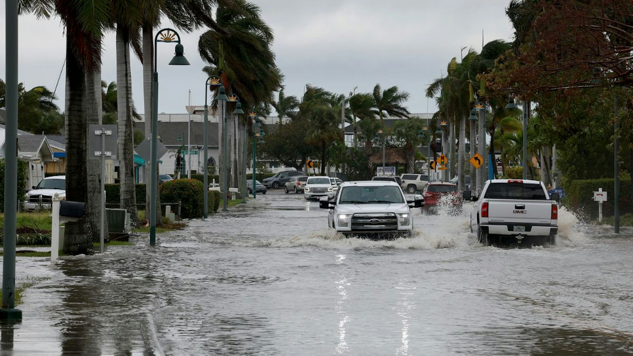 Vehicles drive through a flooded street after Hurricane Nicole came ashore on November 10, 2022 in Fort Pierce, Florida.