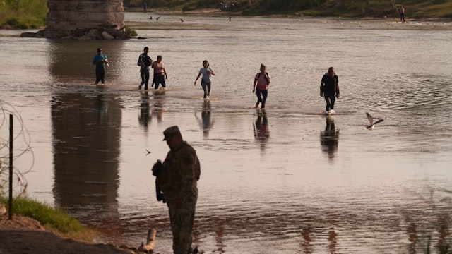 This picture taken on October 9, 2022 shows migrants illegally crossing the Rio Grande River from Mexico to the United States in Eagle Pass, Texas.