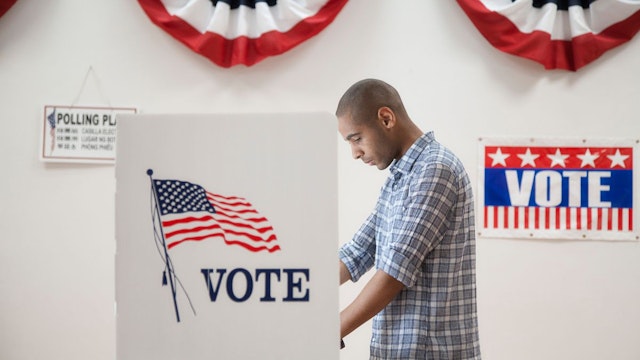 Man voting in polling place - stock photo
