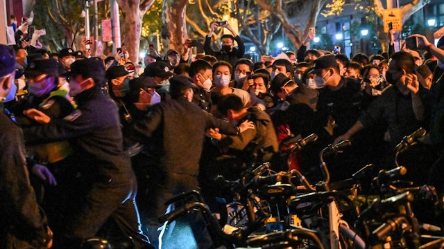 Police and guards arrest a man during some clashes in Shanghai on November 27, 2022, where protests against China's zero-Covid policy took place the night before following a deadly fire in Urumqi, the capital of the Xinjiang region.