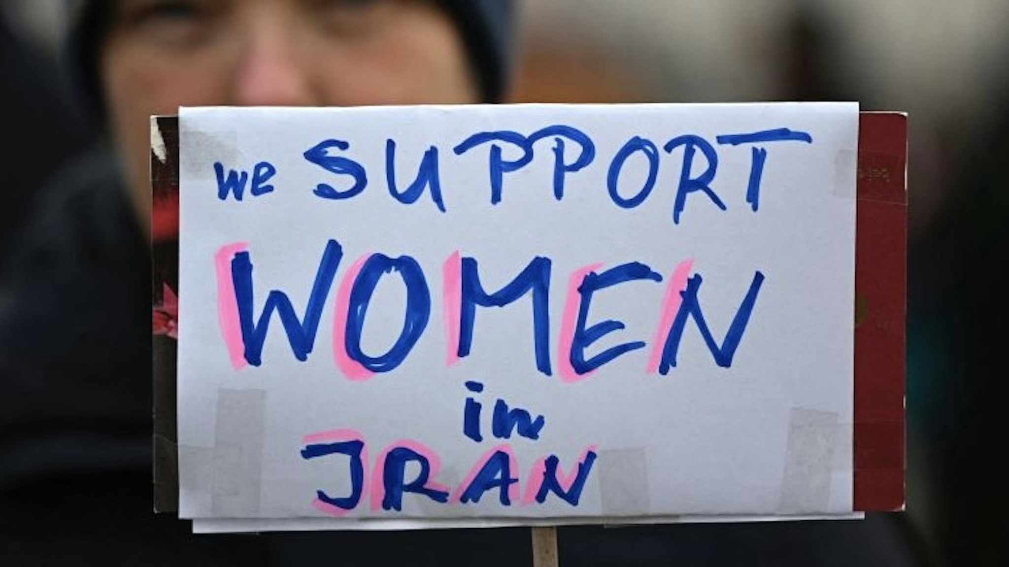 GERMANY-IRAN-DEMONSTRATION-WOMEN A protester holds a placard reading "We support women in Iran" during a womens march in solidarity with demonstrators in Iran in Berlin, on December 10, 2022. (Photo by Tobias Schwarz / AFP) (Photo by TOBIAS SCHWARZ/AFP via Getty Images) TOBIAS SCHWARZ / Contributor