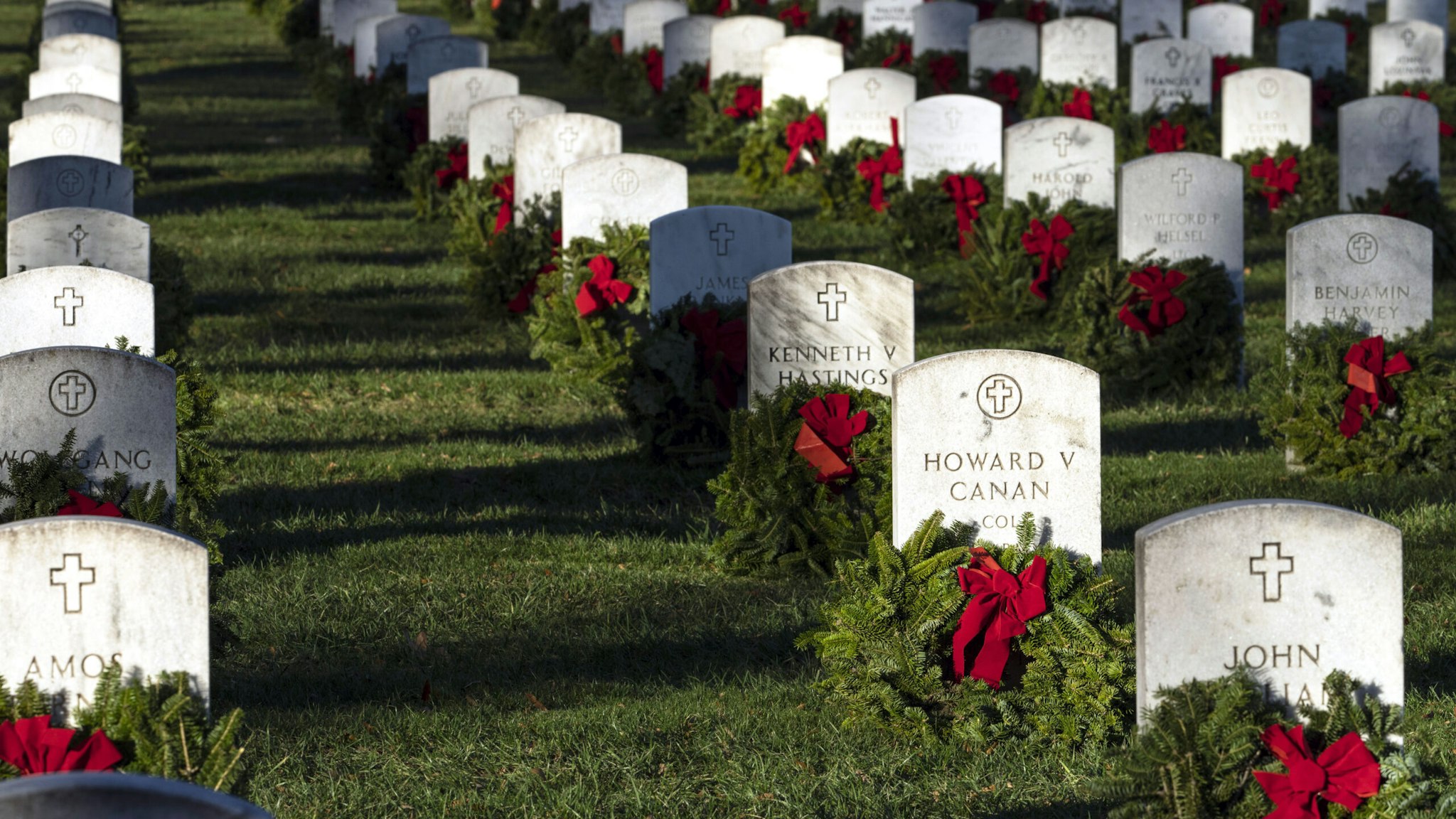 ARLINGTON, VIRGINIA - DECEMBER 17: Christmas wreaths placed by volunteers sit in front of headstones at Arlington National Cemetery on December 17, 2022 in Arlington, Virginia. Thousands of volunteers participated in Wreaths Across America Day, laying wreaths at headstones at Arlington National Cemetery to honor fallen service members. Over 3000 other locations across America, at sea and abroad also participate in the annual event.