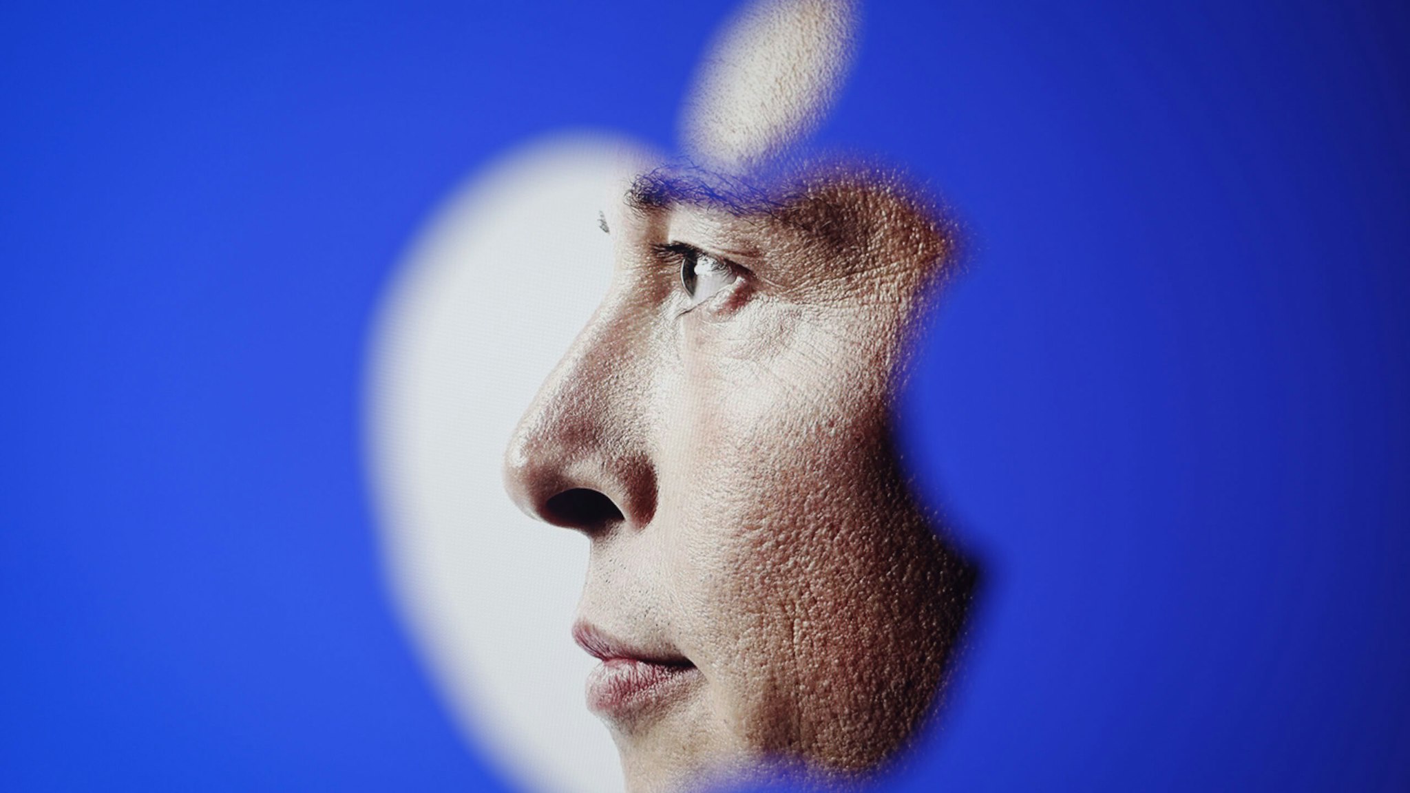 An image of Elon Musk is seen through an Apple logo in this illustration photo in Warsaw, Poland on 30 November, 2022. The revamped Blue Twitter subscription might not be available as in-app purchase on Apple devices when it eventually relaunches. The decision presumably was made so that Twitter can dodge Apples 30 percent cut of App Store purchases. While Elon Musk is publicly tweeting his displeasure with Apple, it appears he wants to avoid having to pay Apples fees.