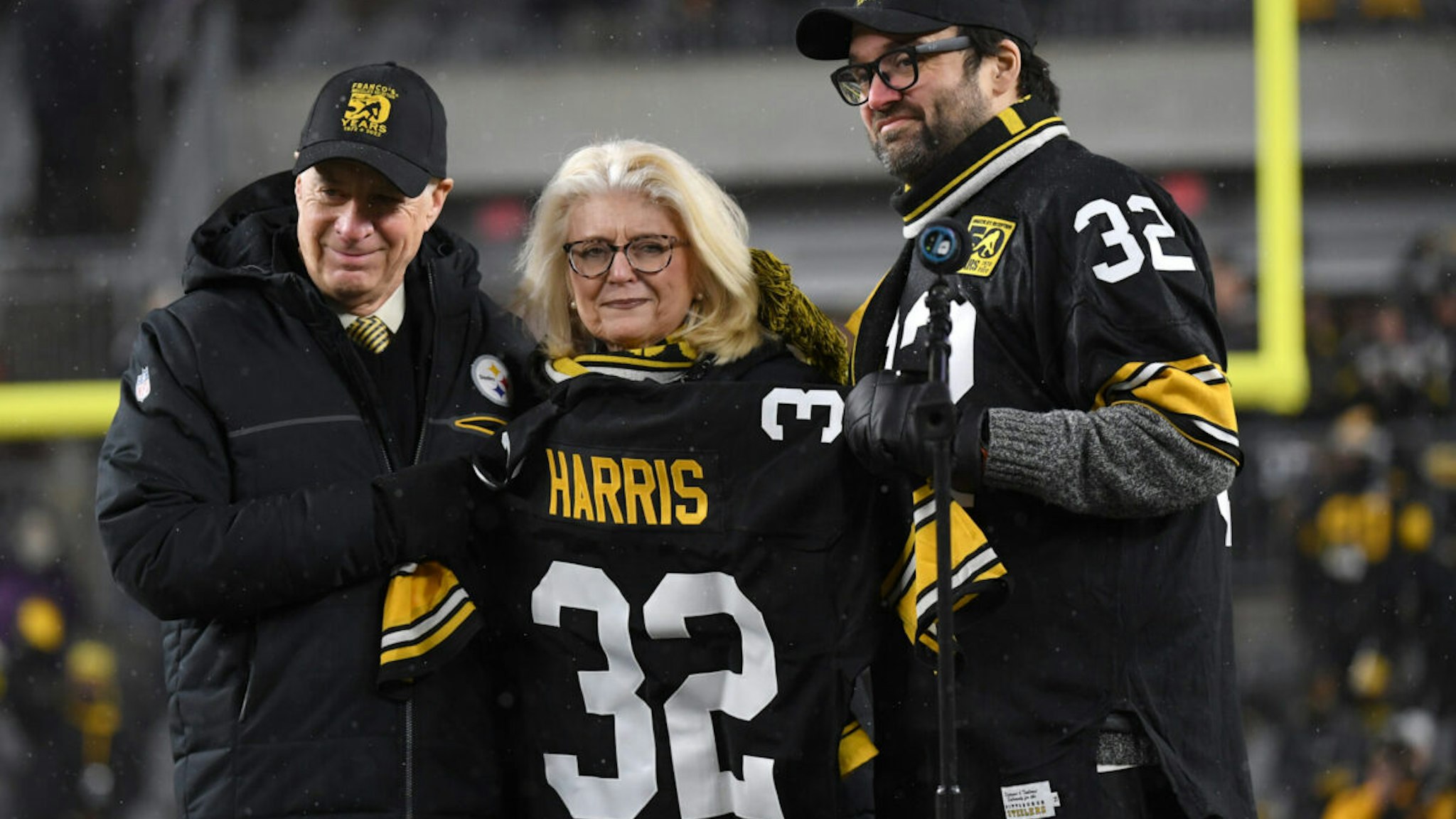Franco Harris #32 is honored in a memorial at halftime with his wife and son in attendance during the game against the Las Vegas Raiders at Acrisure Stadium on December 24, 2022 in Pittsburgh, Pennsylvania