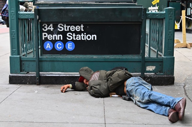 A man sleeps near Penn Station by Madison Square Gardens on September 17, 2020 in New York City. (Photo by Angela Weiss / AFP) (Photo by