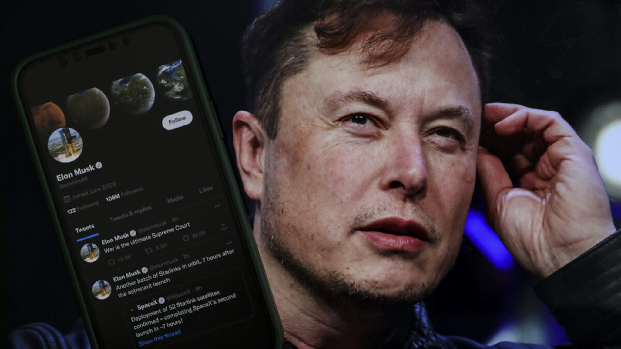 In this photo illustration, Elon Musk's twitter profile is displayed on a mobile phone and the image of him is seen on a computer screen on back of it in Ankara, Turkiye on October 06, 2022
